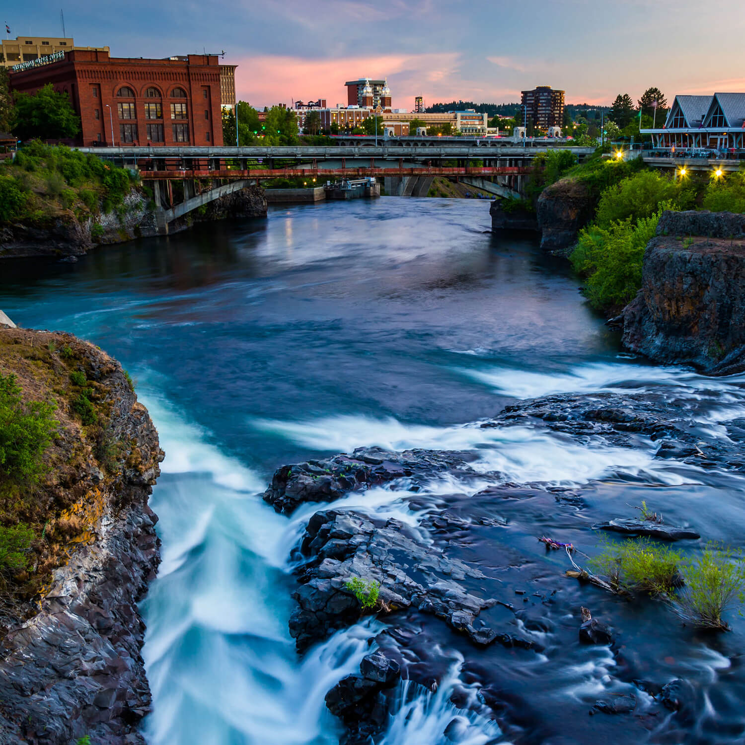 Spokane River flowing under a bridge, with Spokane in the background