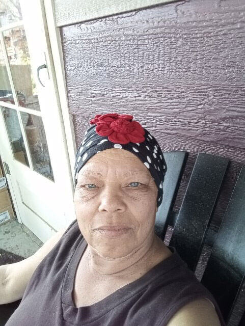 Cancer can't patient sitting with a head wrap on her porch