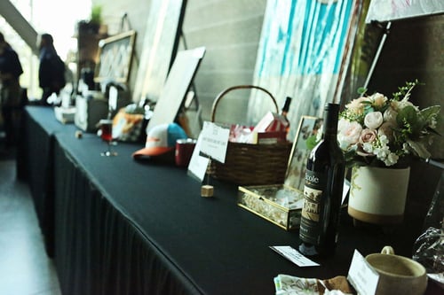 Banquet table of donated items at the Cancer Can't Gala